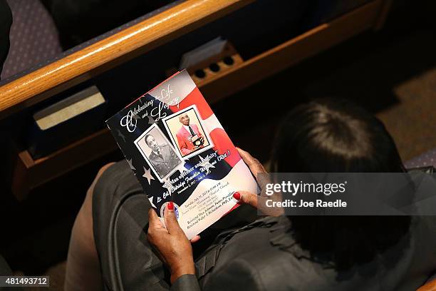 Mourner holds a program with photographs of retired Air Force Lt. Col. Eldridge Williams during his funeral at the Sweet Home Missionary Baptist...