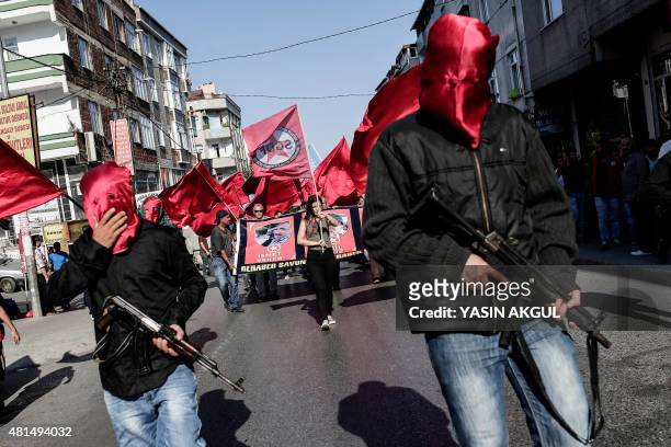 Armed left wing militans escort the coffins of victims who were killed at suicide bomb attack in Suruc, as they arrive at Gazi Cemevi an Alevi...