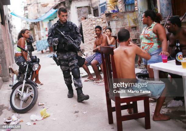 Brazilian military police officer patrols after entering the unpacified Complexo da Mare, one of the largest 'favela' complexes in Rio, on March 30,...