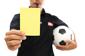 Referee showing a yellow card on white background