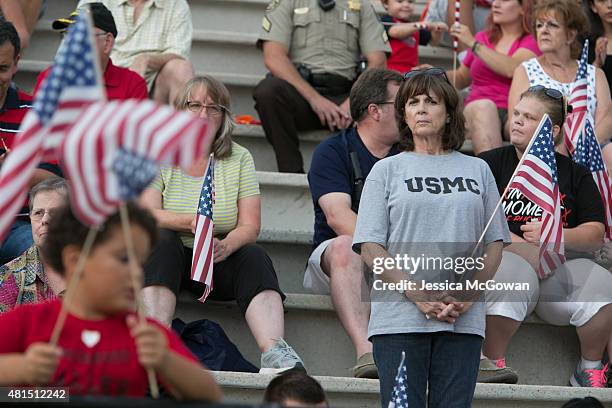 Community members gather in the stands with flags during a memorial held for Marine Lance Cpl. Skip Wells at Sprayberry High School on July 21, 2015...