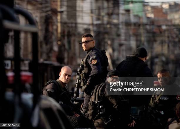 Paramilitary police BOPE elite unit personnel patrol the Favela da Mare shantytown complex in Rio de Janeiro, Brazil, on March 30, 2014 early...