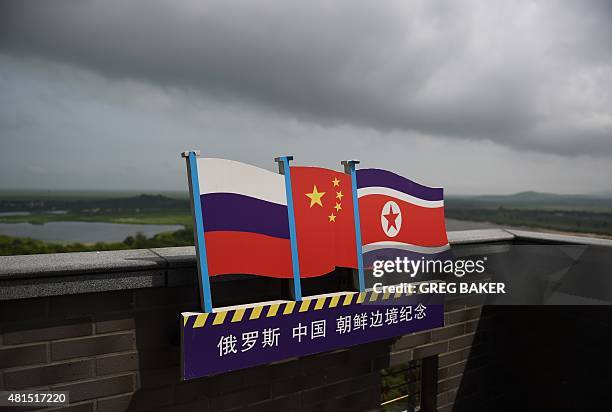 This photo taken on June 25, 2015 shows the flags of Russia , China and North Korea on a viewing tower on the border between the three countries in...