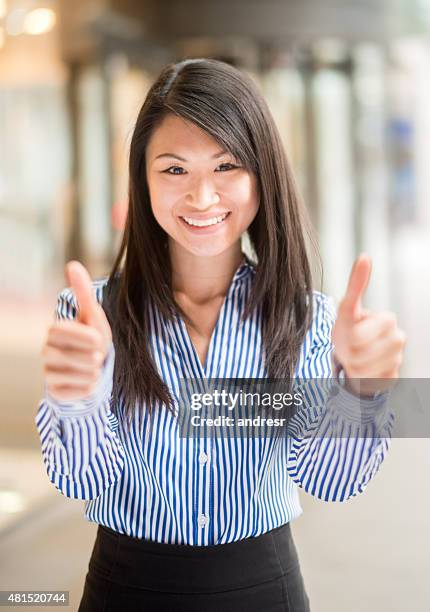 親指を立てろしたアジアのビジネスウーマン - okサイン　女性 ストックフォトと画像
