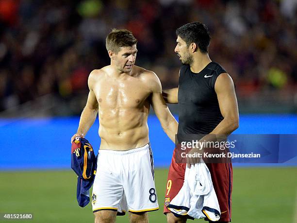 Former Liverpool teammate Luis Suarez of FC Barcelona and Steven Gerrard of the Los Angeles Galaxy walk off the pitch after exchanging jerseys at...