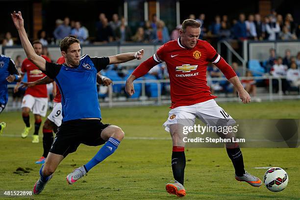 Wayne Rooney of Manchester United drives the ball as Clarence Goodson of San Jose Earthquakes defends during the first half of their International...