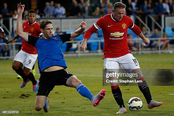 Wayne Rooney of Manchester United drives the ball as Clarence Goodson of San Jose Earthquakes defends during the first half of their International...