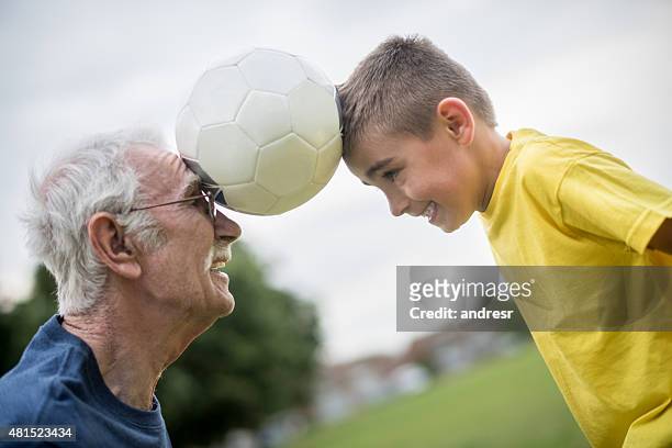 ragazzo e nonno che giocano a calcio insieme - head coach foto e immagini stock