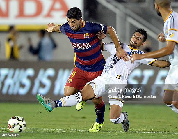 Luis Suarez of FC Barcelona is tackled by A.J. DeLaGarza of Los Angeles Galaxy during the first half of International Champions Cup friendly soccer...