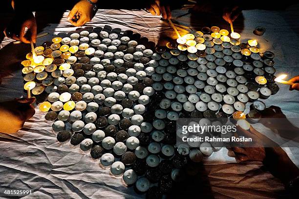 Representative from Muslim, Buddhist and Christian religions light candles during a candle light vigil to remember the victim of the ill-fated flight...