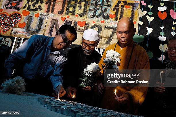 Representative from Muslim, Buddhist and Christian religions light candles during a candle light vigil to remember the victim of the ill-fated flight...