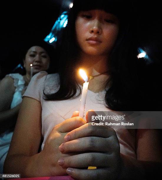 Women holds candle during a candle light vigil to remember the victim of the ill-fated flight MH370 on March 30, 2014 in Kuala Lumpur, Malaysia. The...
