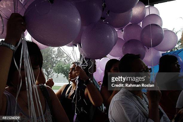 Volunteer from an NGO called Malaysians For Malaysia gets ready to release balloons as a symbol of remembrance for the victim of the ill-fated flight...