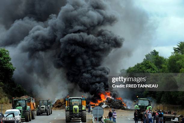 Farmers use tractors and burn tires, hay and manure as they block the highway between Morlaix and Brest during a demonstration against the market...