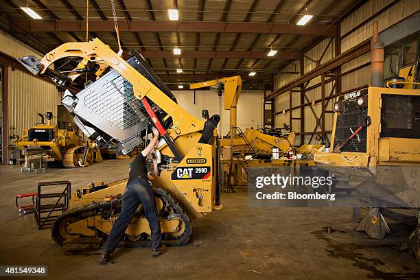 Technician works on a Caterpillar Inc. 259D compact track loader at the Altorfer Cat dealership in East Peoria, Illinois, U.S., on Tuesday, July 21,...