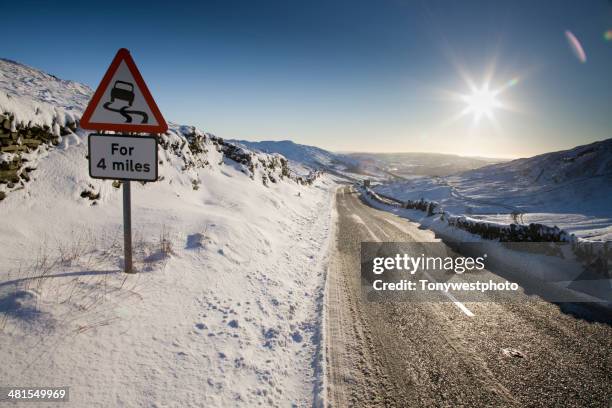mountain road pass in winter, lake district - slippery road sign stock pictures, royalty-free photos & images
