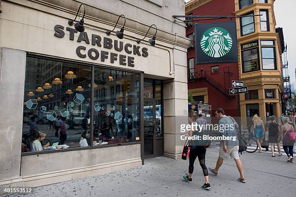 Pedestrians walk towards a Starbucks Corp. Location at Union Square in New York, U.S., on Tuesday, July 21, 2015. Starbucks Corp. Is scheduled to...