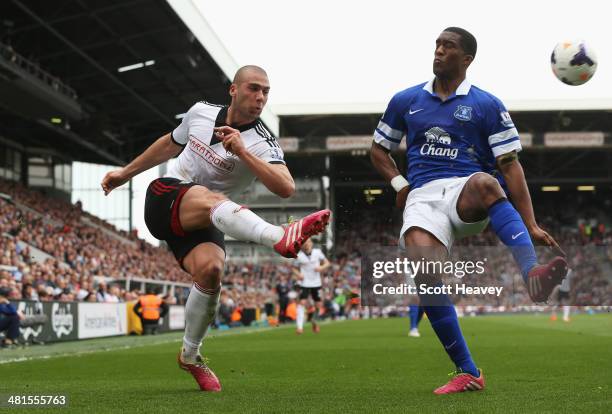 Pajtim Kasami of Fulham crosses as he is closed down by Sylvain Distin of Everton during the Barclays Premier League match between Fulham and Everton...