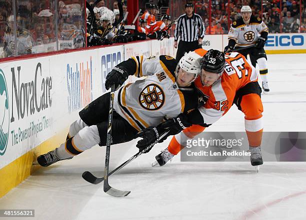 Mark Streit of the Philadelphia Flyers checks Carl Soderberg of the Boston Bruins into the boards on March 30, 2014 at the Wells Fargo Center in...