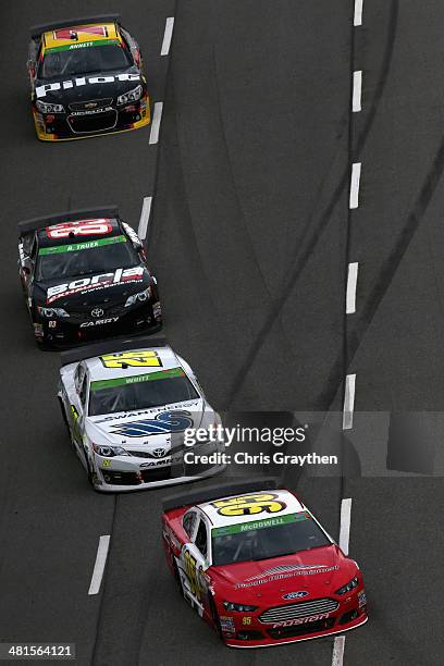 Michael McDowell, driver of the Triangle Office Equipment Ford, leads Cole Whitt, driver of the Swan Energy Toyota, Ryan Truex, driver of the Borla...