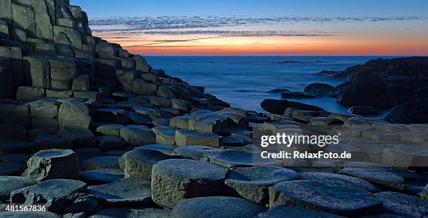 sunset over basalt columns at giants causeway in northern ireland - giant's causeway stockfoto's en -beelden