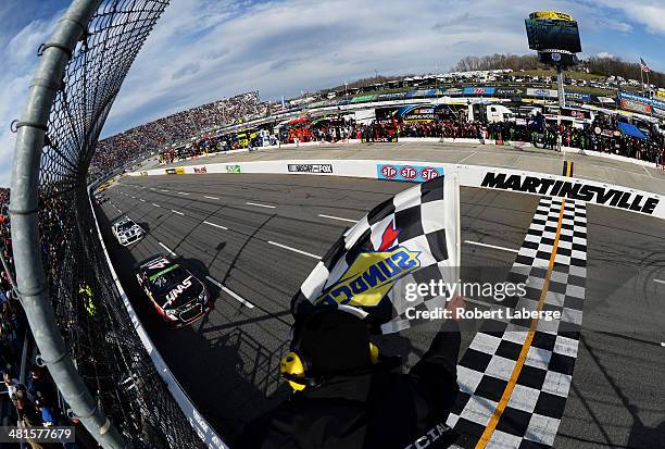 Kurt Busch, driver of the Haas Automation Chevrolet, takes the checkered flag to win the NASCAR Sprint Cup Series STP 500 at Martinsville Speedway on...