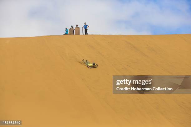 Sandboarding on Sand Dunes In Namibia