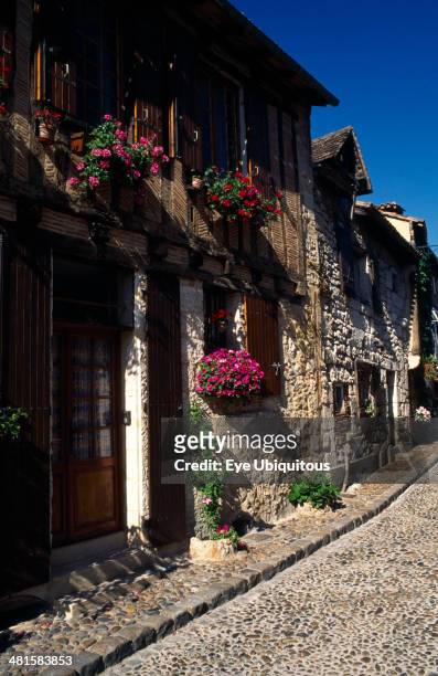 France, Aquitaine, Bergerac, Terrace row of stone houses with wooden shutters and hanging flower baskets outside.