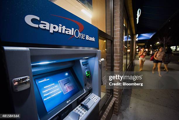 Pedestrians walk past a Capital One Financial Corp. Automated teller machine outside of a bank branch in New York, U.S., on Monday, July 20, 2015....