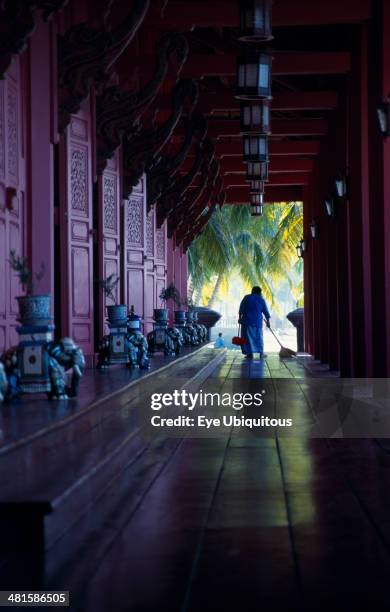 Malaysia, Kedah, Langkawi, The Summer Palace on Pantai Kok beach with woman sweeping the floor of the main pavilion film set for Anna And The King.