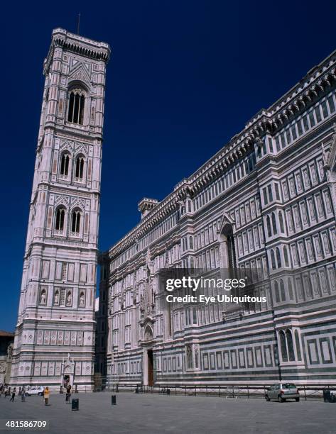 Italy, Tuscany, Florence, The Duomo. Exterior wall and the Campanile, designed by Giotto in 1334 and clad in white, pink and green Tuscan marble.