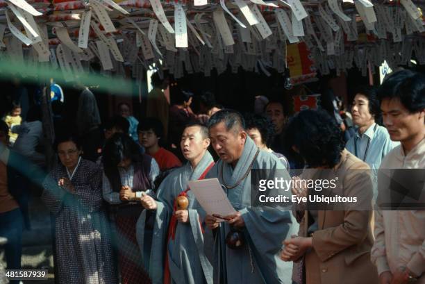 South Korea, Religion, Buddhist, Korean Buddhist monk leads prayers during May celebrations of Buddhas birthday below ceiling hung with paper...