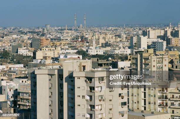 Libya, Tripoli, Cityscape view over housing and urban architecture toward distant Mosque.