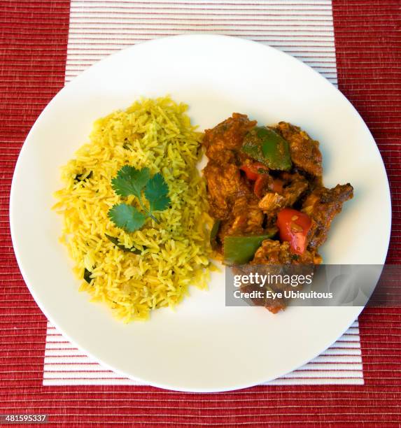 Food, Cooked, Curry, Indian chicken Jalfrezi curry with yellow pilau rice on a white plate.