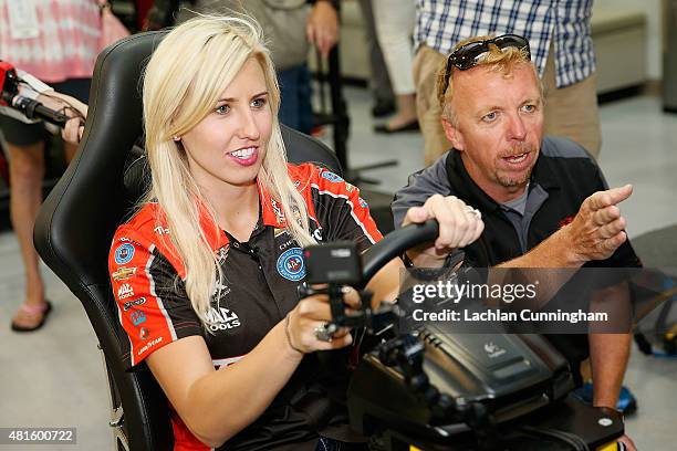 Courtney Force, NHRA's winningest female driver, gets advice from an instructor as she races a racing simulator against her fiance, INDYCAR driver...