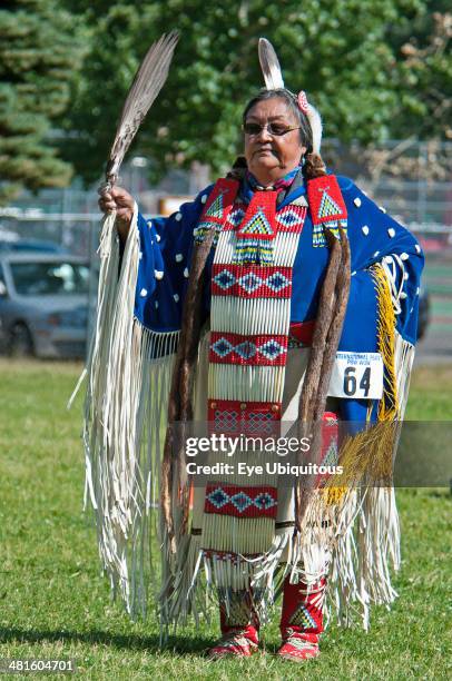 Canada, Alberta, Waterton Lakes National Park, Blackfoot dancer in blue cape trimmed with otter fur and porcupine quill apron holding a feather fan...