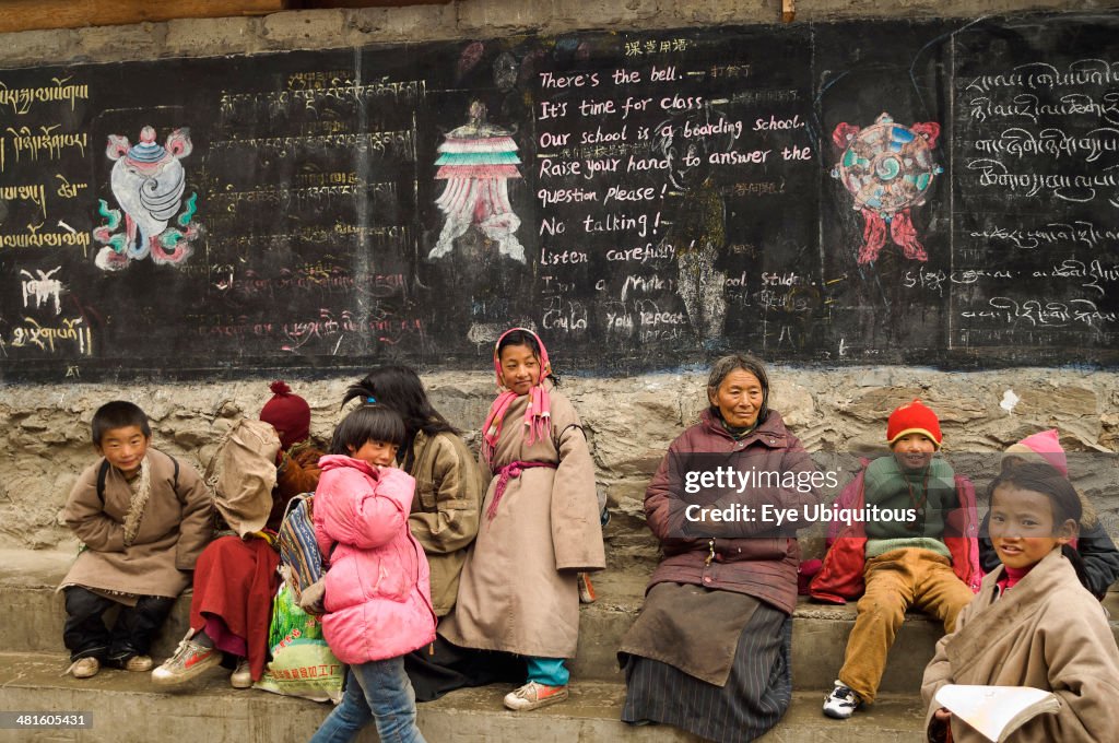 Families at the entrance to a private boarding school in Tibetan region