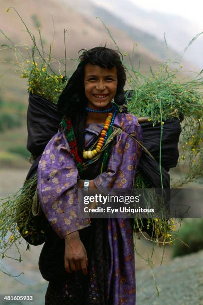 Morocco, Atlas Mountains ,Berber girl with backpack carrying harvested crops.