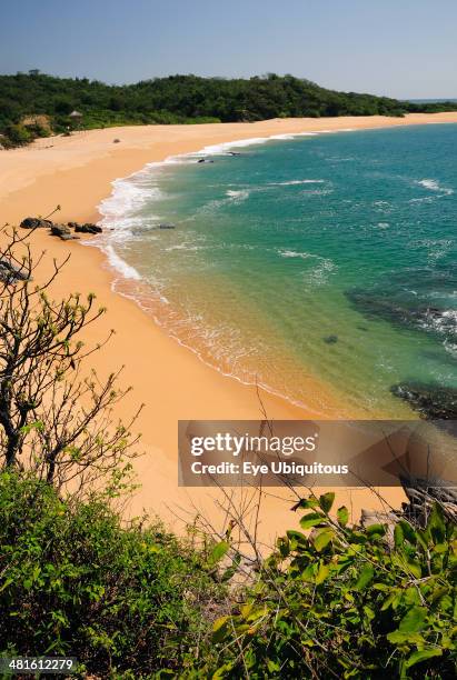 Mexico, Oaxaca, Huatulco, View onto deserted beach at Playa Conejos with turquoise water and golden sand.