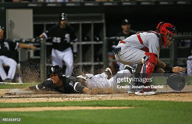 Tyler Saladino of the Chicago White Sox slides in to score a run in the 6th inning as Yadier Molina of the St. Louis Cardinals awaits the throw at...