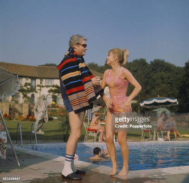 American actor Richard Bradford posed with English actress Judy Geeson on location filming the television adventure series 'Man In A Suitcase' in...
