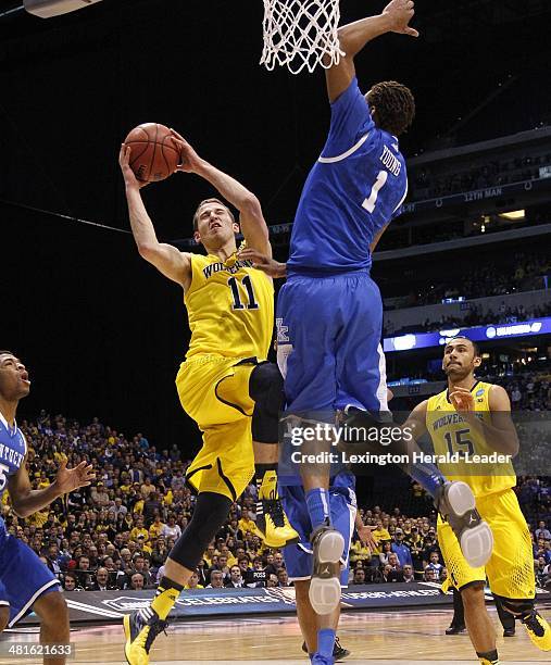 Kentucky Wildcats guard/forward James Young defended as Michigan Wolverines guard Nik Stauskas drove to the basket during the NCAA Tournament's...