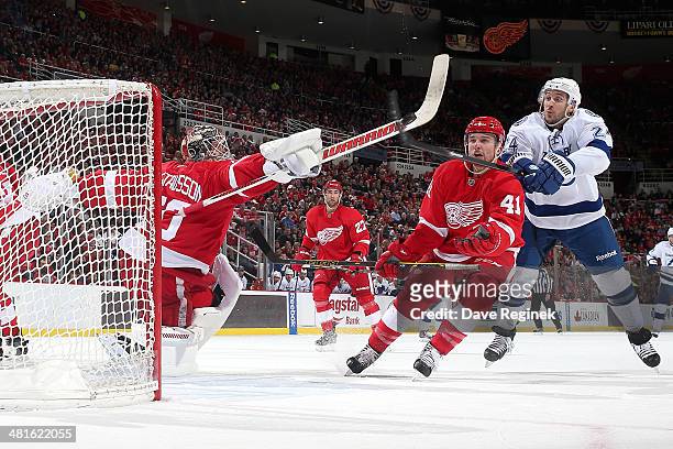 Jonas Gustavsson and Luke Glendening of the Detroit Red Wings battle for an airborne puck with Ryan Callahan of the Tampa Bay Lightning during an NHL...