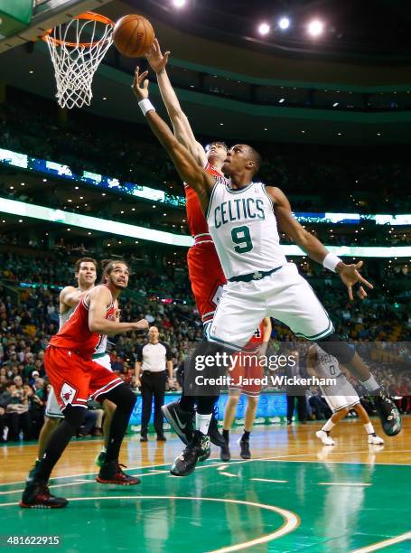 Rajon Rondo of the Boston Celtics drives to the basket in front of Kirk Hinrich of the Chicago Bulls in the first period during the game at TD Garden...