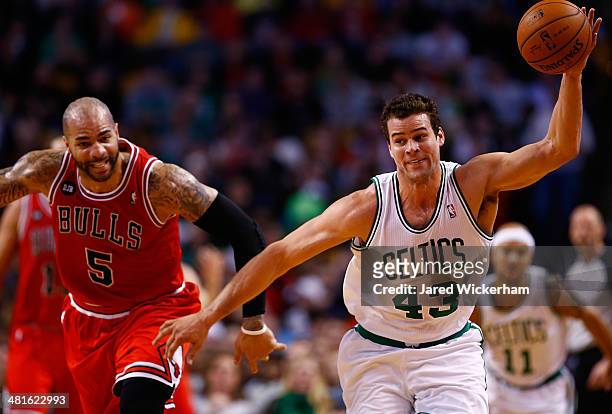 Kris Humphries of the Boston Celtics grabs a loose ball in front of Carlos Boozer of the Chicago Bulls in the first period during the game at TD...