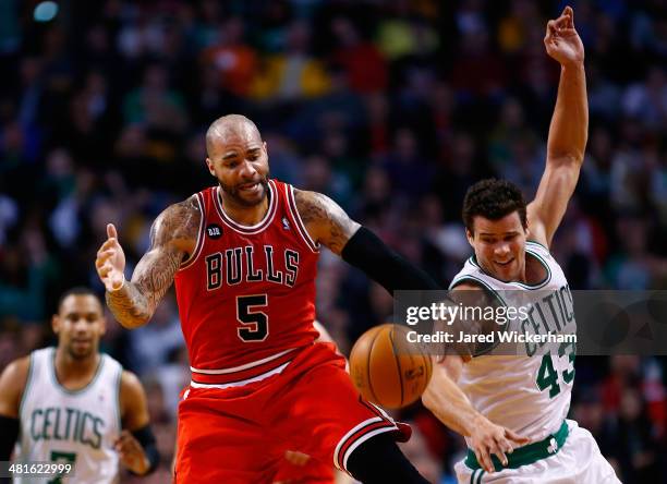 Kris Humphries of the Boston Celtics grabs a loose ball in front of Carlos Boozer of the Chicago Bulls in the first period during the game at TD...