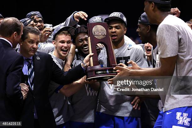 Head coach John Calipari of the Kentucky Wildcats poses with his team and the regional trophy after defeating the Michigan Wolverines 75 to 72 in the...