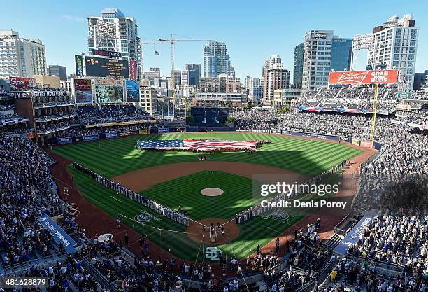 Players line up on the field next to U.S. Military members during pre-game festivities on Opening Night before a baseball game between the Los...