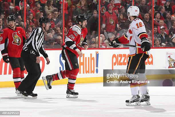 Matt Kassian of the Ottawa Senators gets fired up after a first period fight as Brian McGrattan of the Calgary Flames and teammate Jason Spezza look...