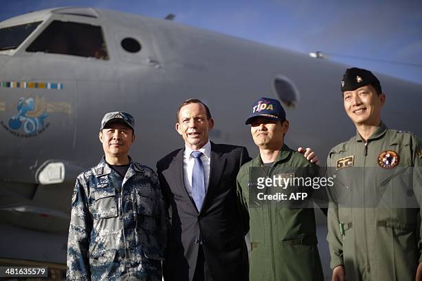 Australian Prime Minister Tony Abbott poses in front of a Royal Australian Air Force AP-3C Orion aircraft with the leaders of China's, Japan's and...